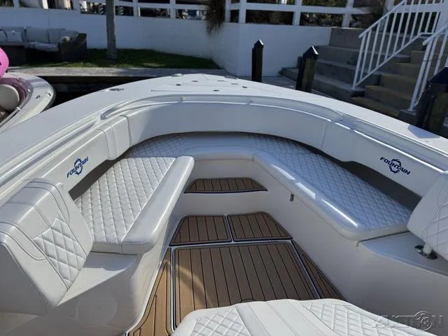 Slide: The Image of 2023 Fountain 34 CC boat with white quilted seating and teak flooring. - 30