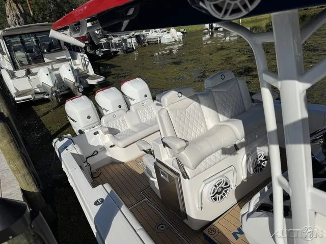 Slide: The Image of 2023 Fountain 34 CC boat with triple outboard engines docked in a marina. - 36