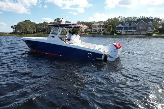 Slide: The Image of 2023 Fountain 34 CC boat on a lake near waterfront homes. - 4