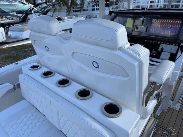 Slide: The Image of 2023 Fountain 34 CC boat interior with white seating and advanced dashboard controls. - 44
