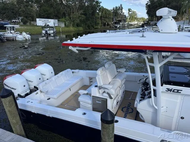 Slide: The Image of 2023 Fountain 34 CC boat with triple Mercury engines docked in a scenic marina. - 46