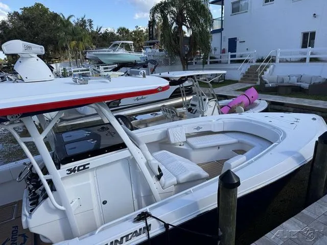 Slide: The Image of 2023 Fountain 34 CC boat docked at marina with other vessels nearby. - 48