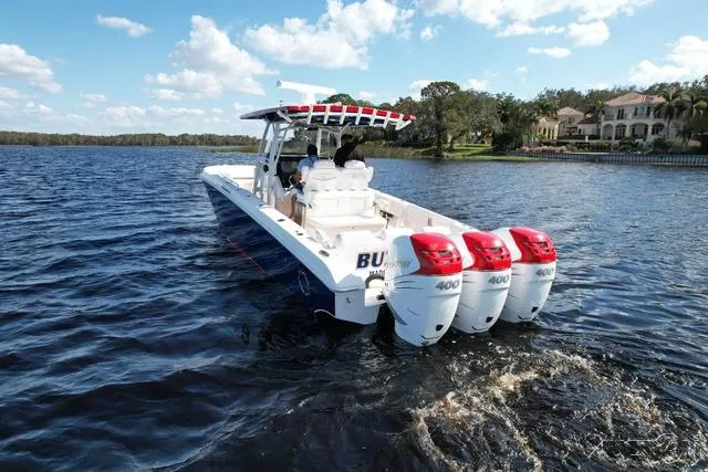 Slide: The Image of 2023 Fountain 34 CC boat with triple 400 HP engines on a lake. - 6
