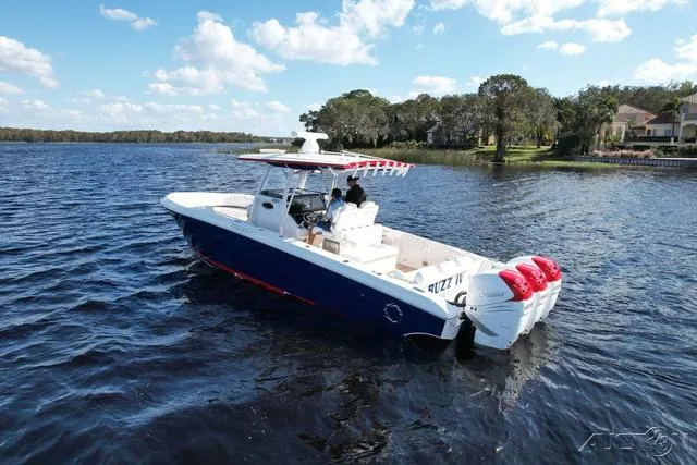 Slide: The Image of 2023 Fountain 34 CC boat cruising on a lake under a blue sky. - 8