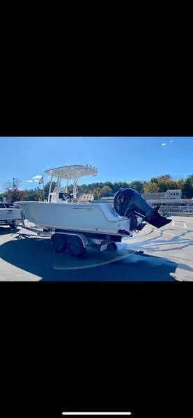 Slide: The Image of 2023 Sportsman 231 Heritage boat on trailer under clear blue sky. - 2