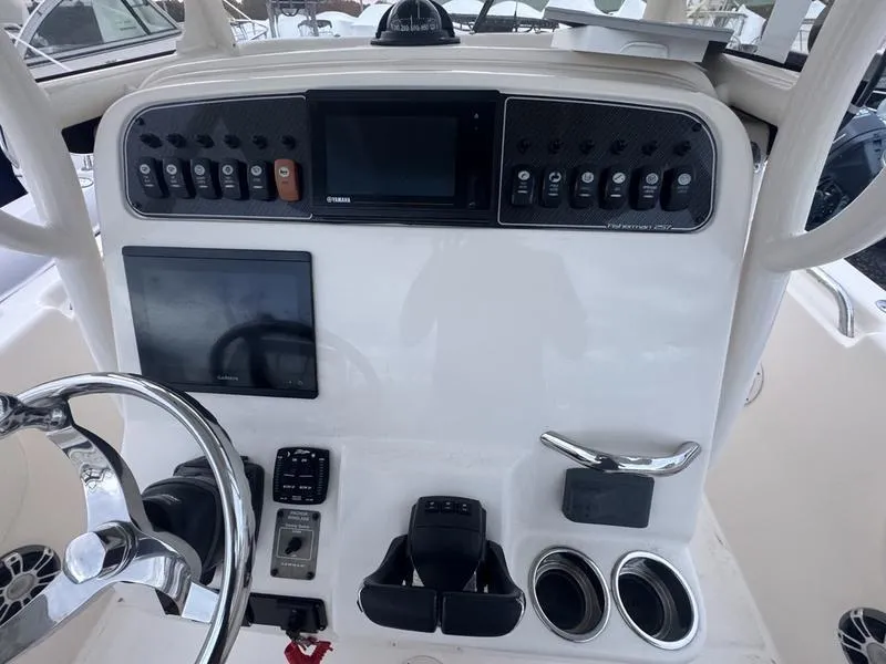 Slide: The Image of 2022 Grady-White 257 Fisherman boat dashboard with steering wheel and control panel. - 4