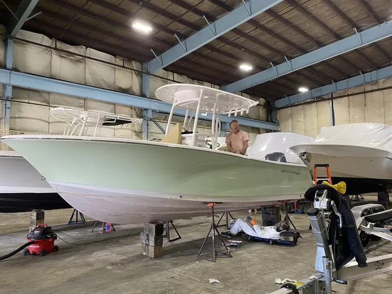 The Image of 2022 Sportsman 231 Heritage boat in a warehouse, undergoing maintenance. - 1