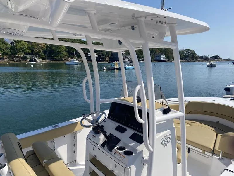 Slide: The Image of 2022 Sportsman 231 Heritage boat interior with console and seating on a calm lake. - 13