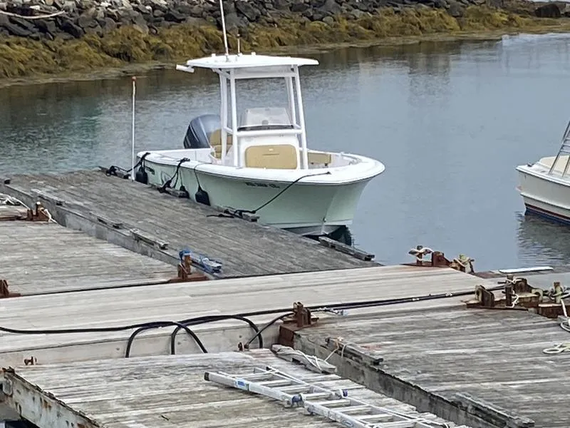 Slide: The Image of 2022 Sportsman 231 Heritage boat docked at a marina. - 14