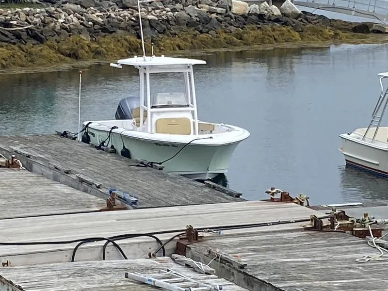 Slide: The Image of 2022 Sportsman 231 Heritage boat docked in a calm marina setting. - 15