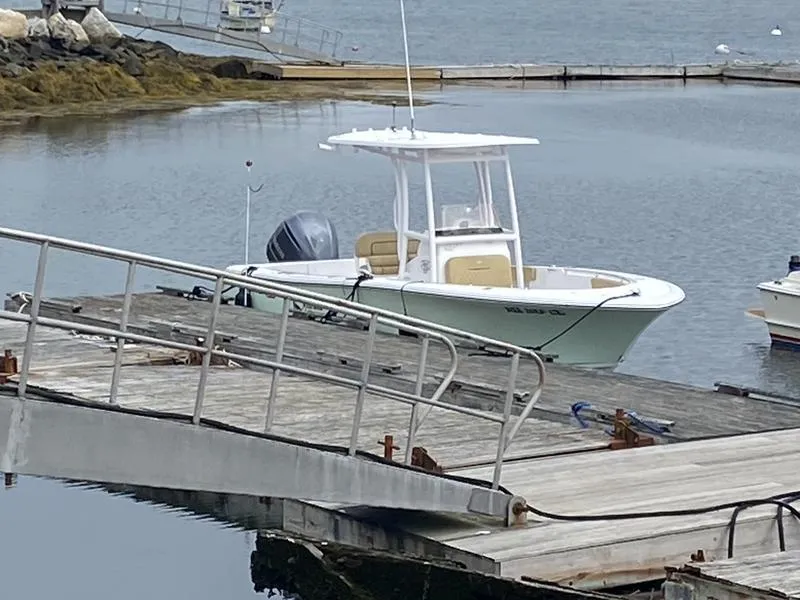 Slide: The Image of 2022 Sportsman 231 Heritage boat docked at a marina. - 17