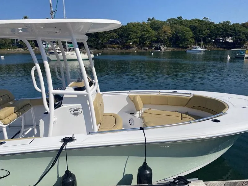Slide: The Image of 2022 Sportsman 231 Heritage boat docked on a serene lake with lush greenery. - 6