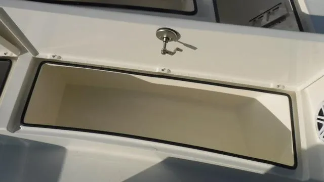 Slide: The Image of Pathfinder 2500 Hybrid 2025 boat storage compartment with open lid and latch. - 11