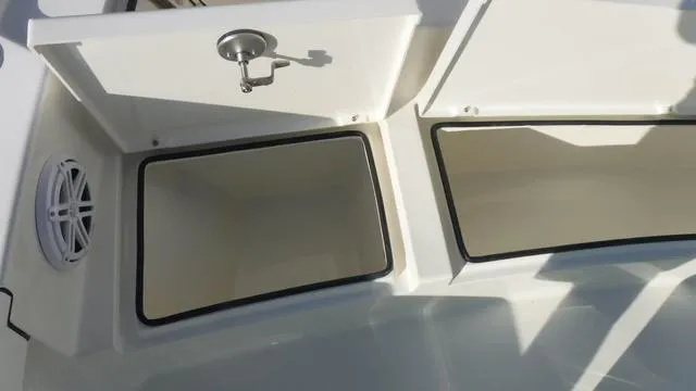 Slide: The Image of Pathfinder 2500 Hybrid 2025 boat storage compartments with open lids and speaker. - 12