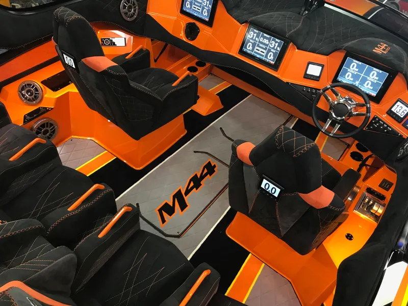Slide: The Image of 2018 Daves Custom Boats M-44 interior with vibrant orange and black design, advanced controls. - 10
