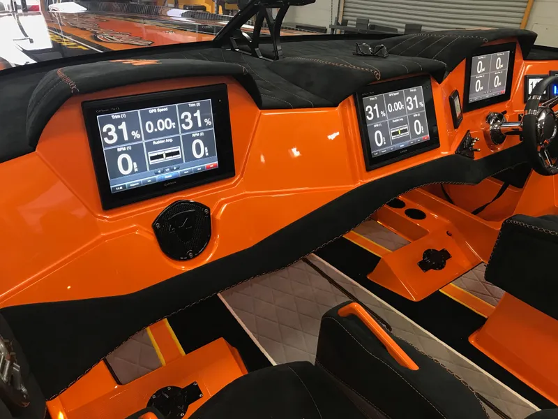 Slide: The Image of 2018 Daves Custom Boats M-44 dashboard with digital displays and vibrant orange interior. - 13