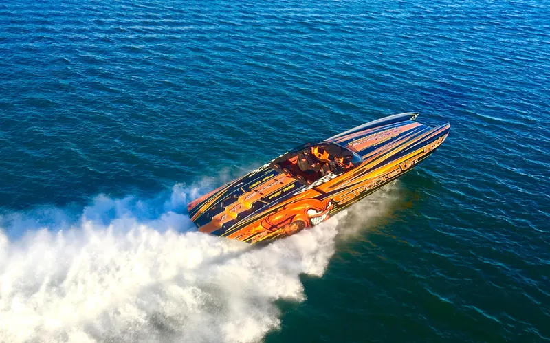 Slide: The Image of 2018 Daves Custom Boats M-44 speeding on open water, vibrant design, creating a dynamic wake. - 3