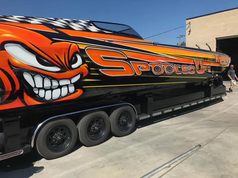 Slide: The Image of 2018 Daves Custom Boats M-44 with vibrant graphics and "Spooled Up" text on trailer. - 4
