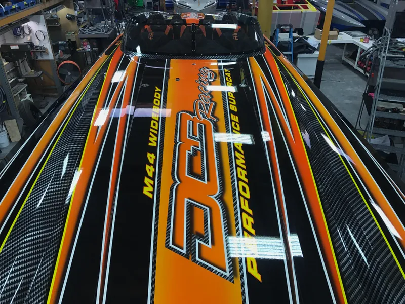 Slide: The Image of 2018 Daves Custom Boats M-44 with vibrant orange and black racing design. - 7