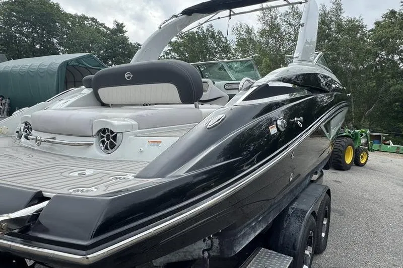 Slide: The Image of 2020 Crownline Eclipse E255 boat on trailer, sleek black design, parked outdoors. - 6