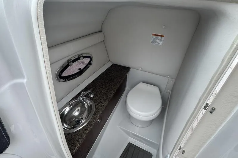 Slide: The Image of 2020 Crownline Eclipse E255 boat interior bathroom with sink and toilet. - 8