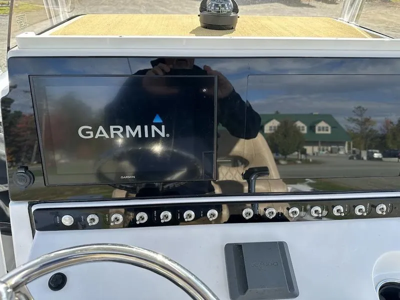 Slide: The Image of Garmin display on 2020 Sportsman 241 Heritage boat dashboard with control switches. - 3