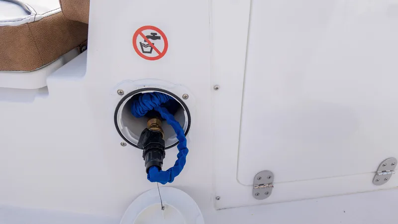 Slide: The Image of Stingray 216CC 2025 boat fuel port with no-fuel symbol and blue hose. - 13