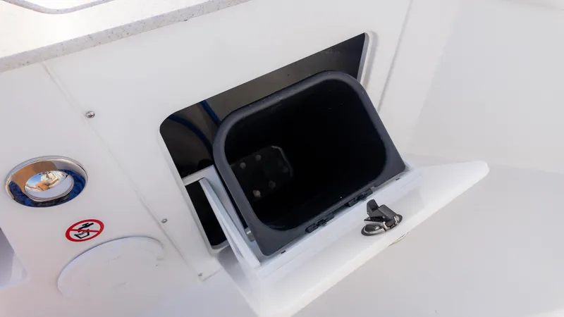 Slide: The Image of Stingray 216CC 2025 boat storage compartment with open hatch and safety sign. - 14