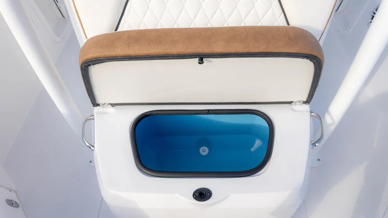 Slide: The Image of 2025 Stingray 216CC boat seat with open storage compartment, featuring blue interior. - 16