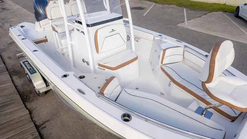 Slide: The Image of 2025 Stingray 216CC boat with white and tan interior, parked on a trailer. - 19