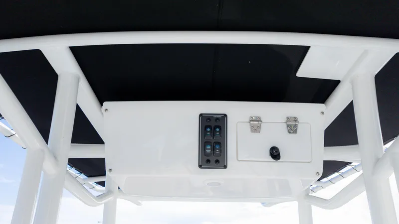 Slide: The Image of 2025 Stingray 216CC boat console with switches and storage compartment. - 27