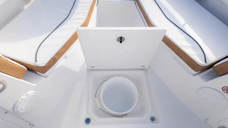 Slide: The Image of 2025 Stingray 216CC boat interior with white seating and storage compartment. - 30