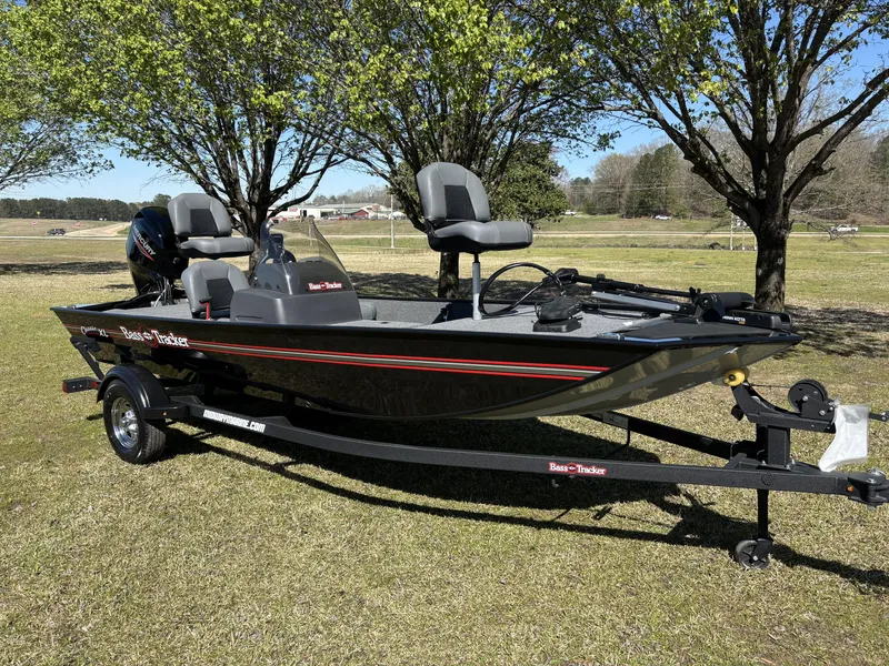 Slide: The Image of 2025 Tracker Bass Tracker Classic XL boat on trailer, parked on grass under trees. - 8