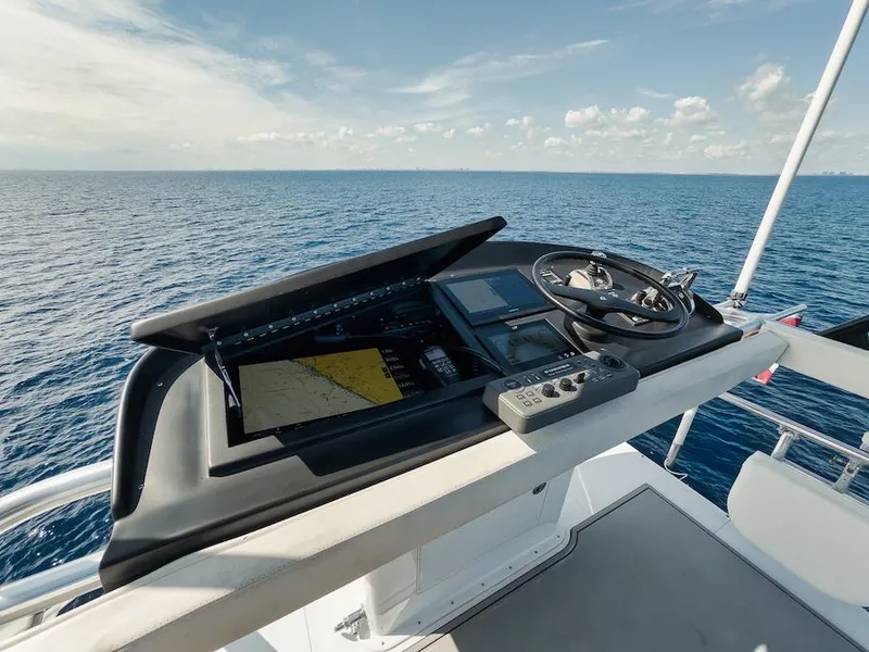 Slide: The Image of Flybridge of 2016 Merritt 86' yacht with navigation controls, steering wheel, and ocean view. - 25