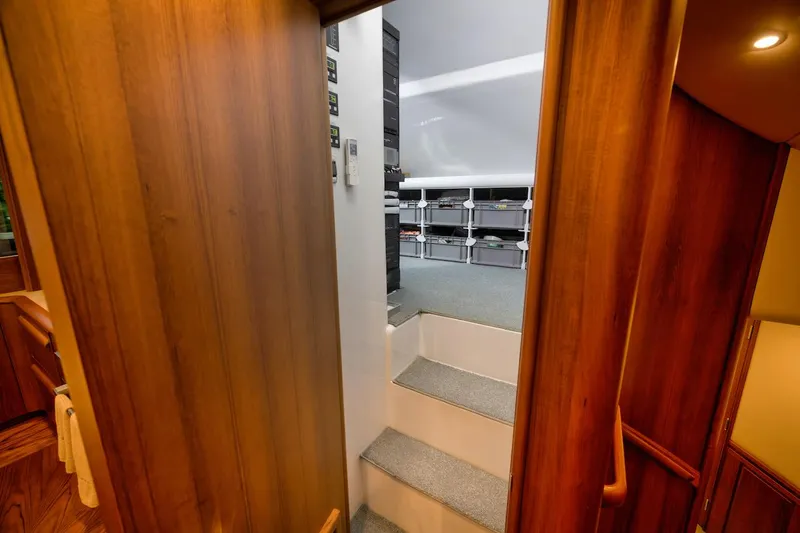Slide: The Image of Interior view of 2016 Merritt 86' Enclosed Flybridge, featuring wooden paneling and carpeted stairs. - 45