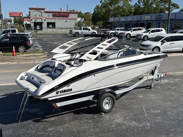 Slide: The Image of 2025 Yamaha Boats 195S in mist gray on a galvanized trailer, parked in a lot. - 15