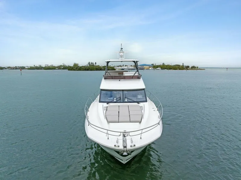 Slide: The Image of 2022 Prestige 520 yacht cruising on calm waters under a clear sky. - 48