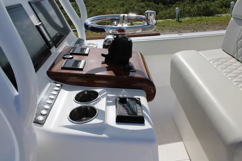 Slide: The Image of 2022 Front Runner 26 Center Console boat dashboard with steering wheel and controls. - 16