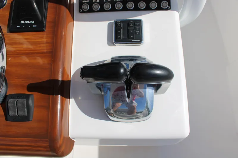 Slide: The Image of 2022 Front Runner 26 Center Console boat controls with Suzuki throttle and switches. - 21