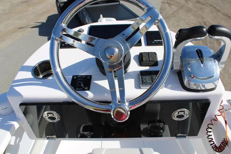 Slide: The Image of 2022 Front Runner 26 Center Console boat helm with steering wheel and controls. - 23