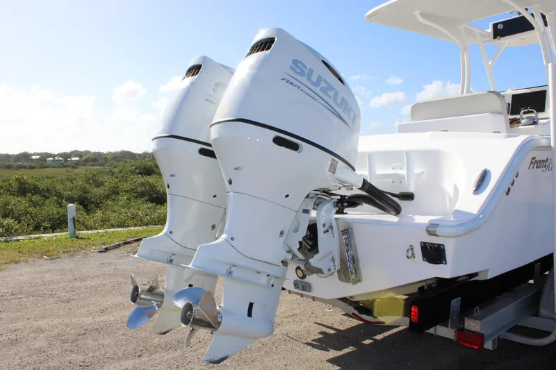 Slide: The Image of 2022 Front Runner 26 Center Console with dual Suzuki outboard motors, parked outdoors. - 33