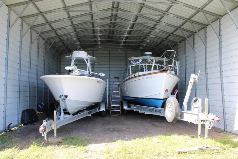 Slide: The Image of Two boats stored in a metal shelter, including a 2022 Front Runner 26 Center Console. - 38