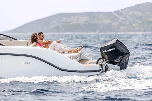 Slide: The Image of Couple relaxing on 2024 Rand Supreme 27 boat in open water. - 11