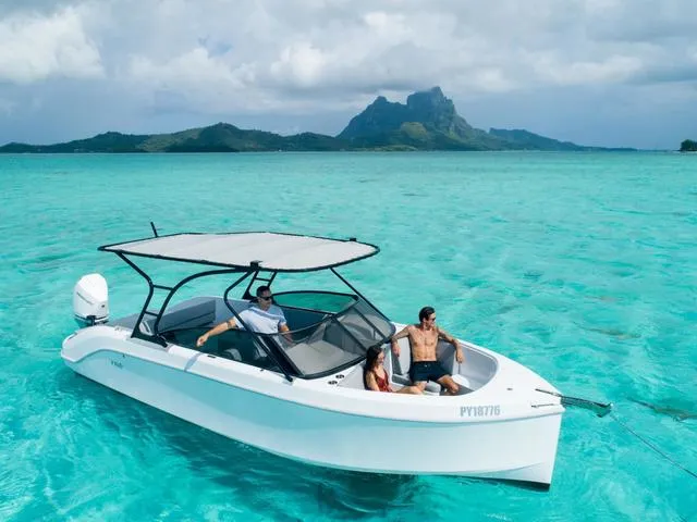 Slide: The Image of 2024 Rand Supreme 27 boat cruising in turquoise waters with scenic island backdrop. - 4