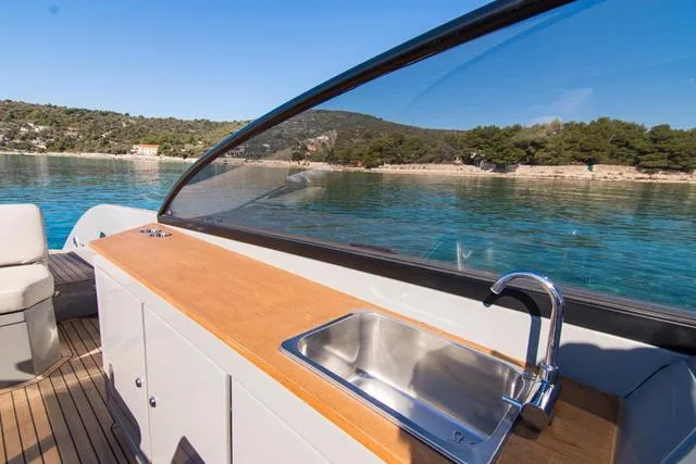 Slide: The Image of 2024 Rand Supreme 27 boat with sleek design, featuring a modern sink and scenic water view. - 9