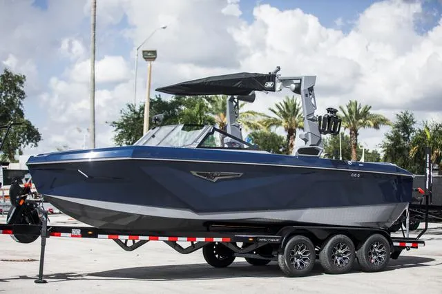 Slide: The Image of 2024 Nautique S23 boat on trailer, parked outdoors under a cloudy sky. - 1