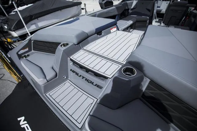Slide: The Image of 2024 Nautique S23 boat interior with sleek gray seating and cup holders. - 10