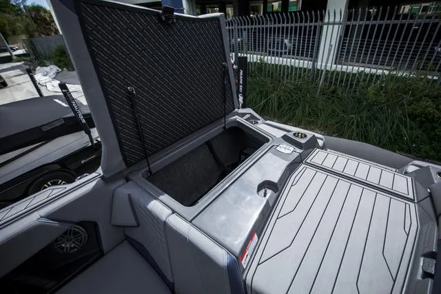Slide: The Image of 2024 Nautique S23 boat storage compartment with open lid, showcasing interior space. - 15