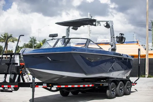 Slide: The Image of 2024 Nautique S23 boat on trailer, sleek design, blue exterior, parked outdoors. - 3