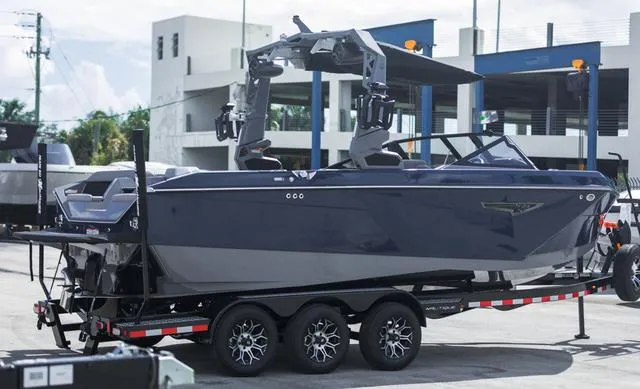 Slide: The Image of 2024 Nautique S23 boat on trailer in urban setting. - 6